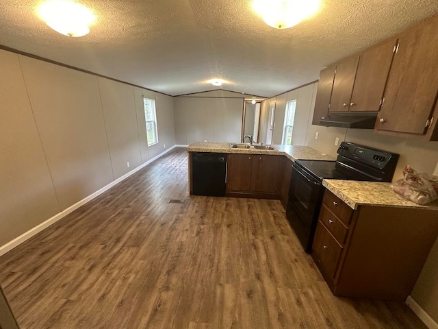 kitchen with lofted ceiling, kitchen peninsula, black appliances, a textured ceiling, and dark hardwood / wood-style floors