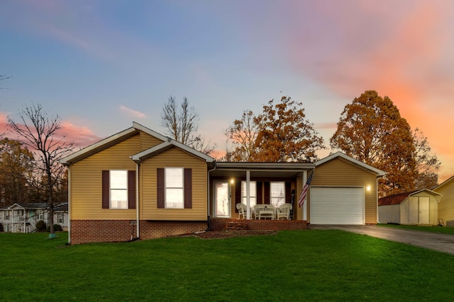 single story home featuring a garage, a shed, a lawn, and a porch