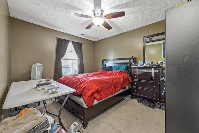 bedroom with ceiling fan, light colored carpet, and a textured ceiling