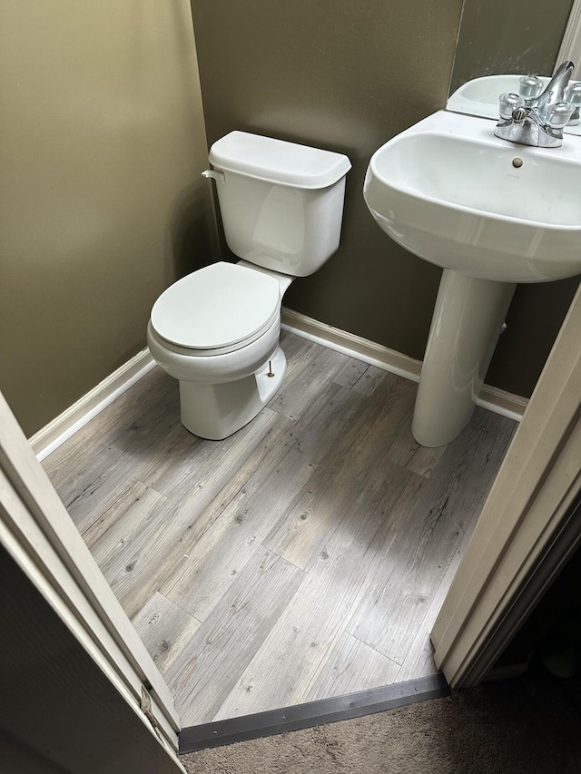 bathroom with toilet and wood-type flooring