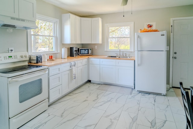 kitchen featuring white cabinets, white appliances, extractor fan, and sink