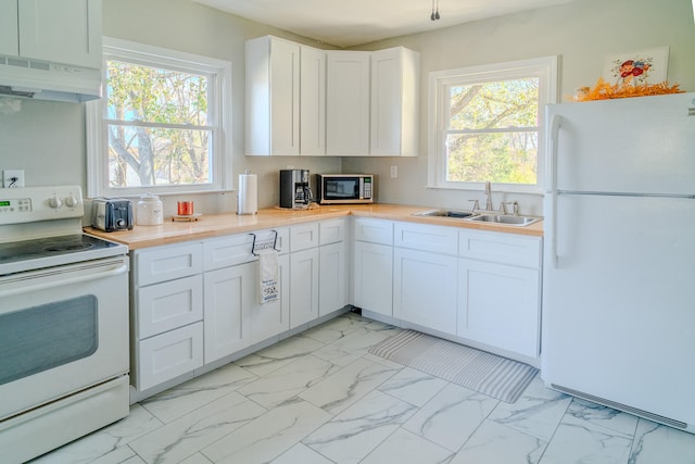 kitchen featuring white cabinetry, sink, and white appliances