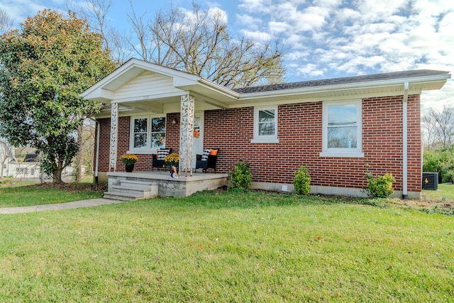 view of front of home with a front lawn and central AC