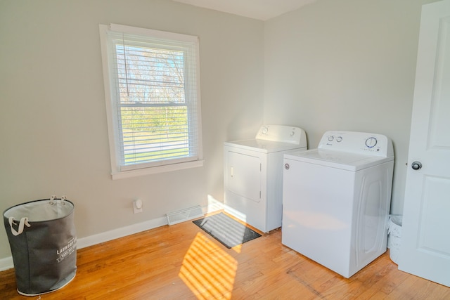 washroom featuring hardwood / wood-style floors and washer and dryer