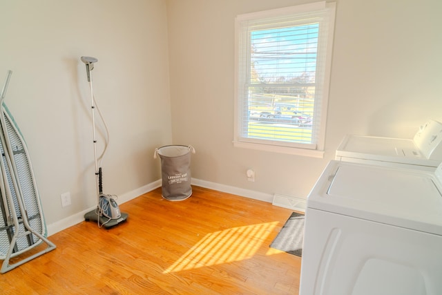 clothes washing area featuring hardwood / wood-style flooring and washer and dryer