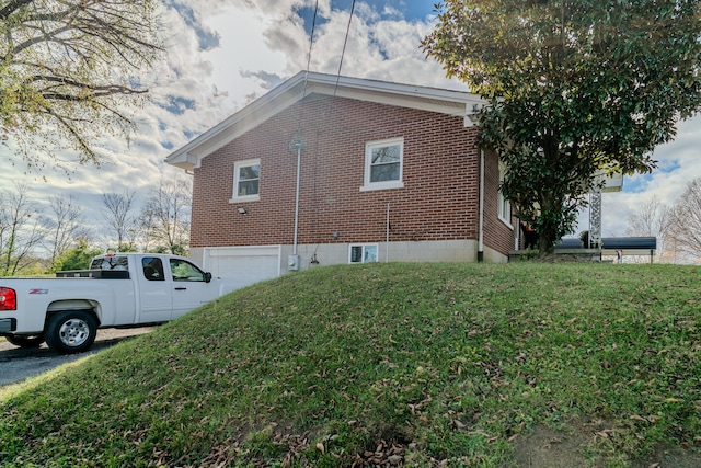 view of side of home with a lawn and a garage