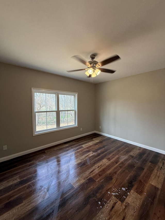 unfurnished room with baseboards, a ceiling fan, and dark wood-style flooring