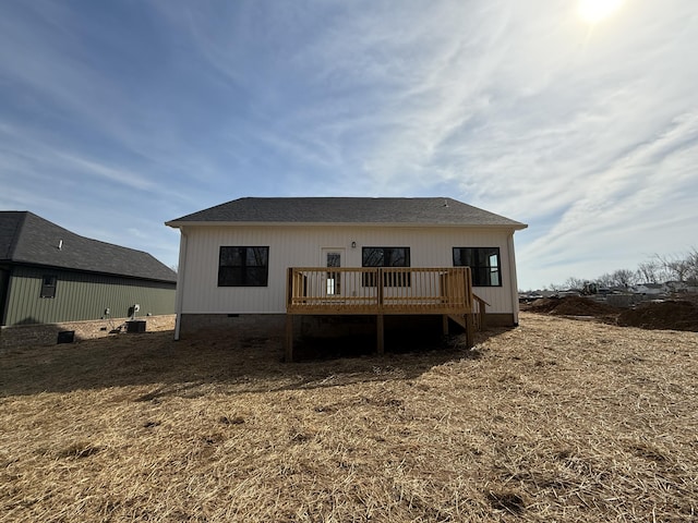 rear view of property with crawl space, a wooden deck, and roof with shingles