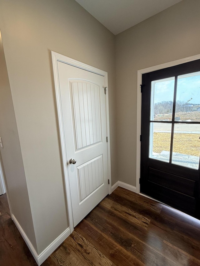 entryway with baseboards and dark wood-type flooring