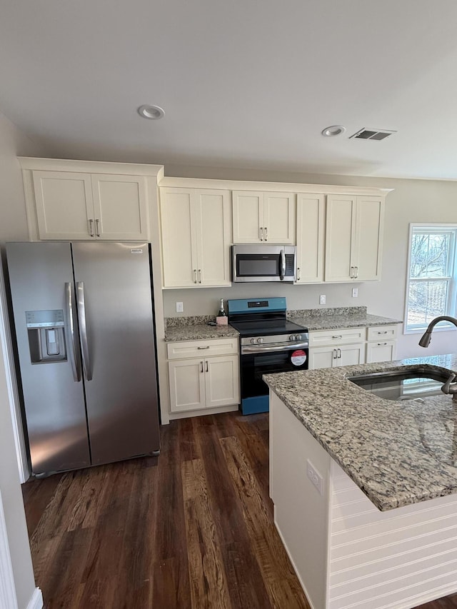 kitchen featuring a sink, stainless steel appliances, white cabinets, and dark wood-style flooring