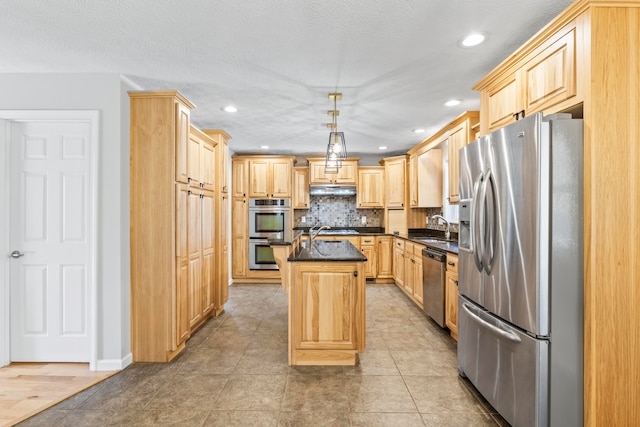 kitchen with pendant lighting, light brown cabinets, a kitchen island, and appliances with stainless steel finishes