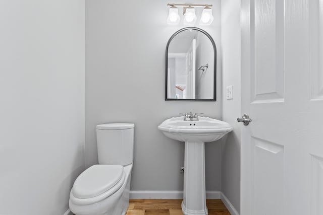 bathroom with hardwood / wood-style flooring and toilet