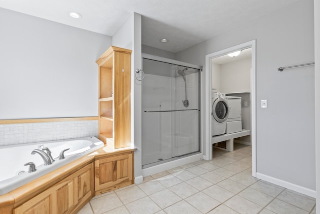 bathroom with shower with separate bathtub, a textured ceiling, tile patterned floors, and washer / dryer