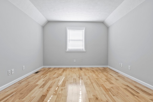 bonus room featuring a textured ceiling, vaulted ceiling, and wood-type flooring