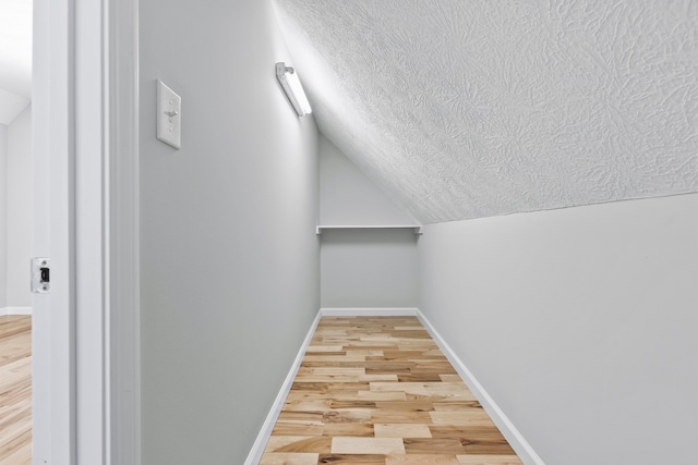 walk in closet featuring wood-type flooring and vaulted ceiling