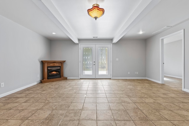 unfurnished living room with beam ceiling, light tile patterned floors, and french doors