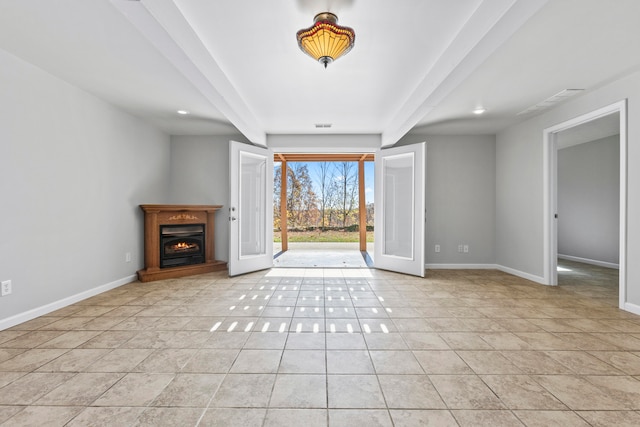 unfurnished living room with light tile patterned flooring, beamed ceiling, and french doors