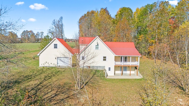 rear view of property with a patio area, a yard, and a balcony