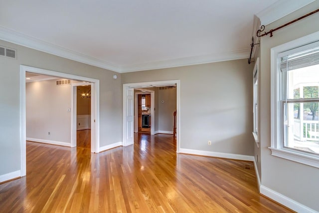 spare room featuring ornamental molding and light wood-type flooring