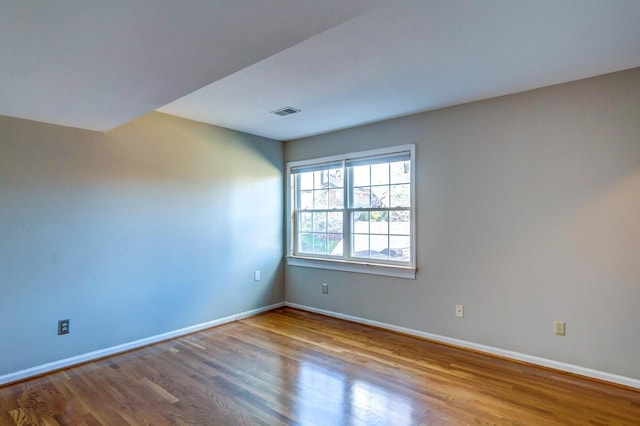 unfurnished room with hardwood / wood-style flooring