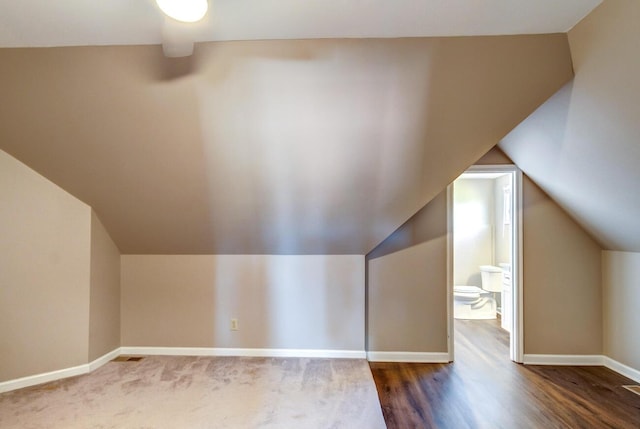 additional living space featuring vaulted ceiling and dark hardwood / wood-style floors