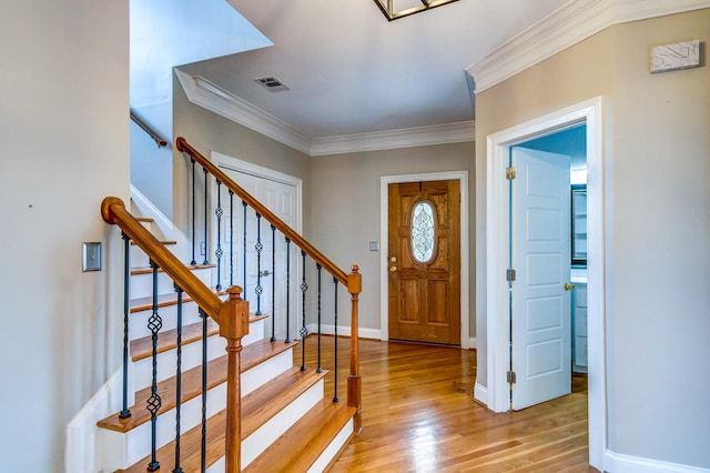 foyer with ornamental molding and light wood-type flooring