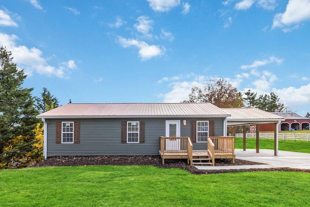 rear view of property featuring a lawn and a wooden deck