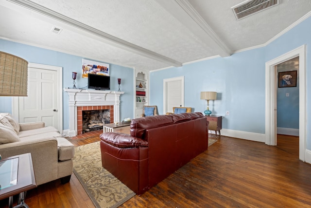 living room featuring built in shelves, dark hardwood / wood-style floors, a textured ceiling, a fireplace, and crown molding