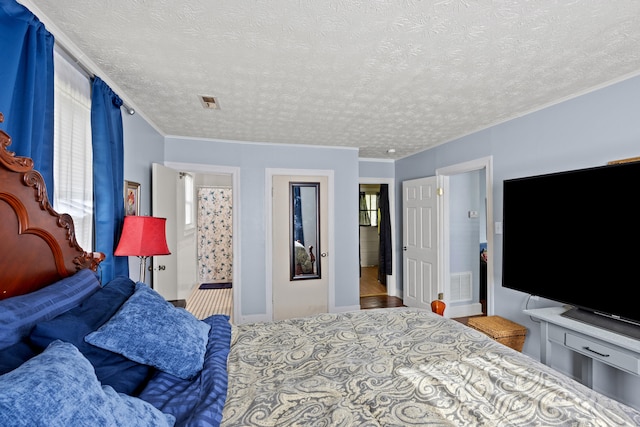 bedroom with multiple windows, a textured ceiling, and crown molding