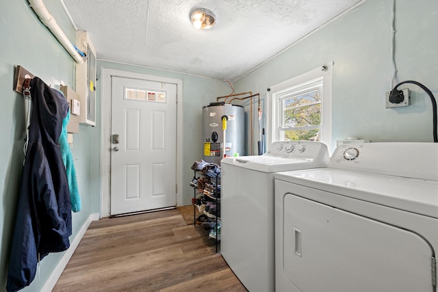 clothes washing area featuring hardwood / wood-style flooring, washer and dryer, a textured ceiling, and water heater