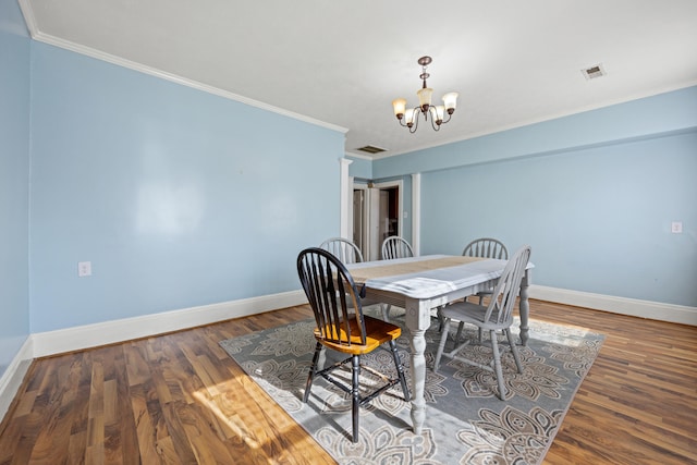 dining space with an inviting chandelier, dark hardwood / wood-style flooring, and ornamental molding