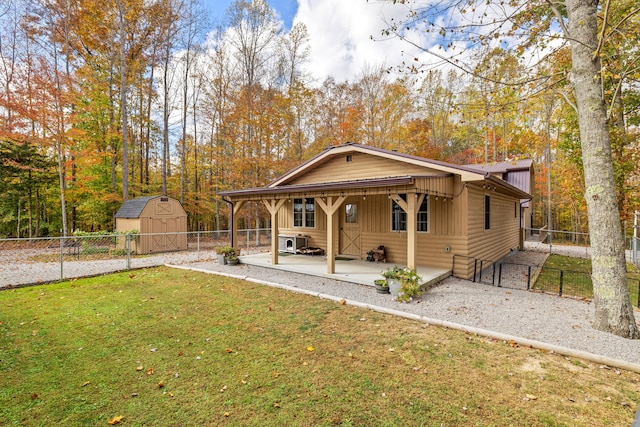 view of front of property with a shed, a front yard, and a patio area