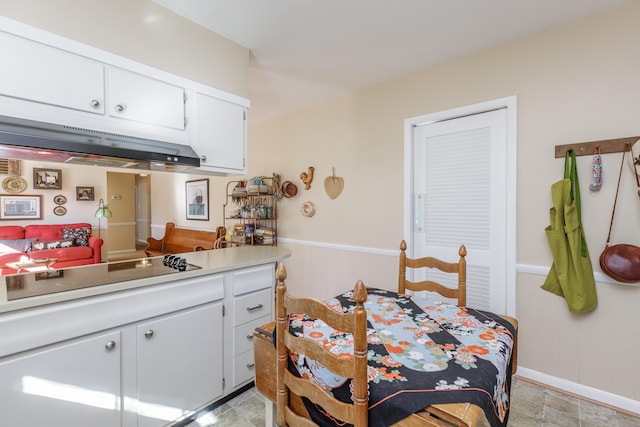 kitchen featuring white cabinetry and cooktop