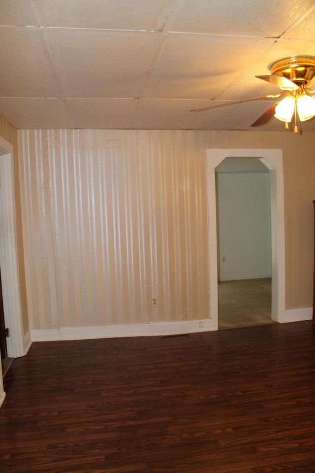 spare room with dark hardwood / wood-style flooring, a paneled ceiling, and ceiling fan