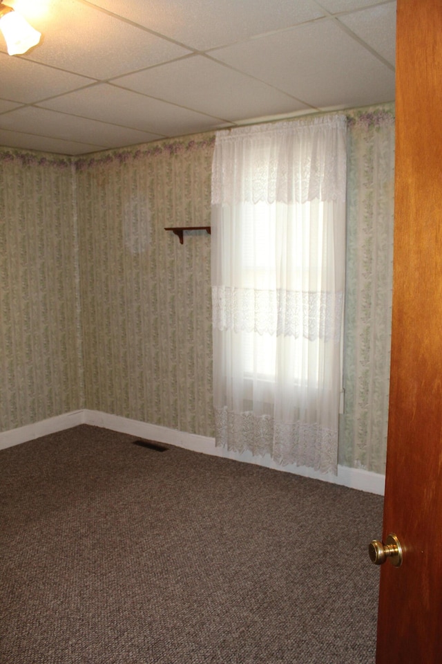 spare room with a drop ceiling and carpet floors