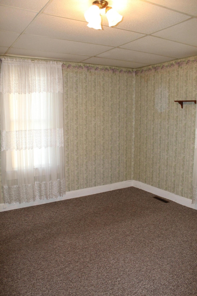 empty room featuring carpet flooring and a drop ceiling