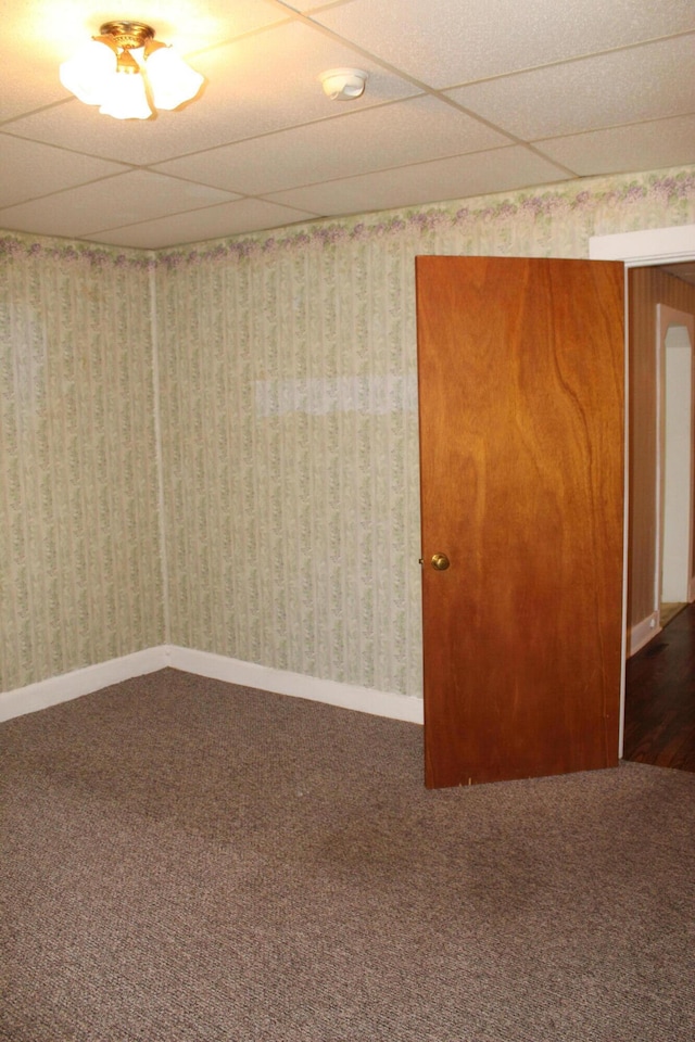 carpeted spare room with a paneled ceiling