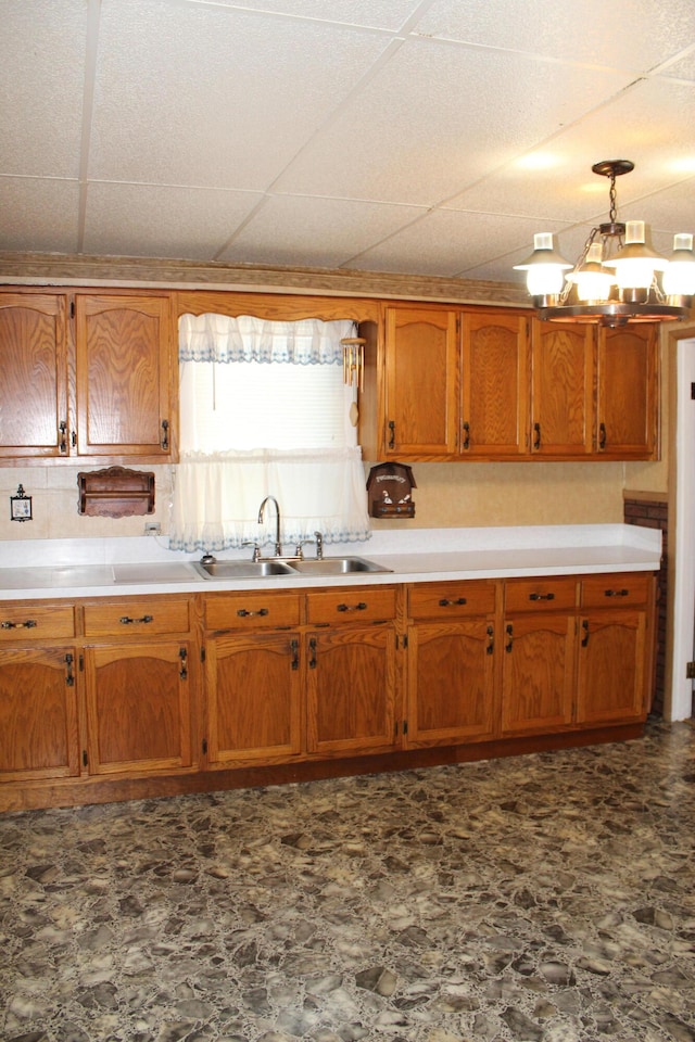 kitchen with a paneled ceiling, pendant lighting, and sink