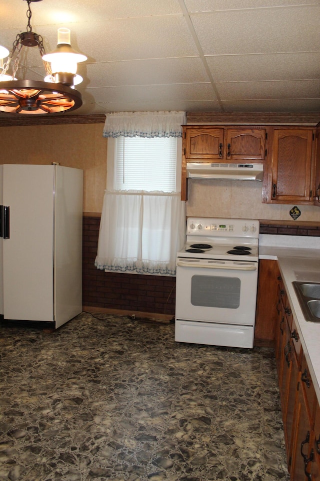 kitchen with white appliances, a paneled ceiling, sink, and an inviting chandelier