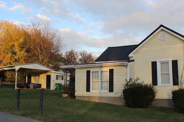 view of side of property featuring a yard and a carport