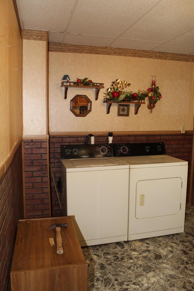 laundry room with washer and dryer and wooden walls