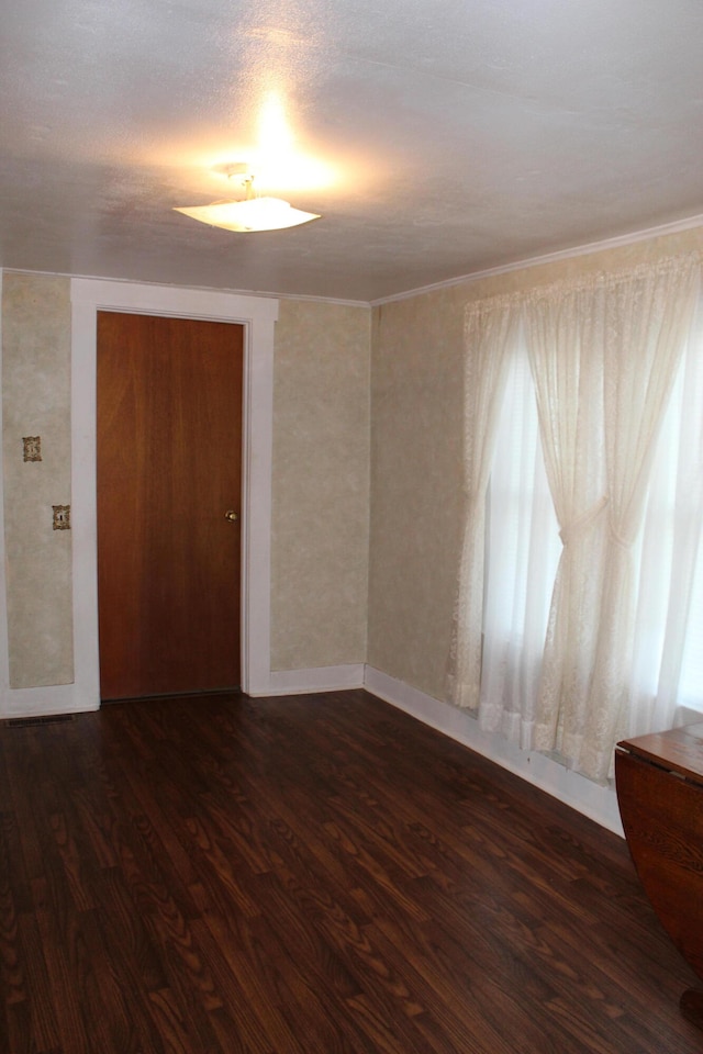 empty room featuring a textured ceiling and dark hardwood / wood-style floors