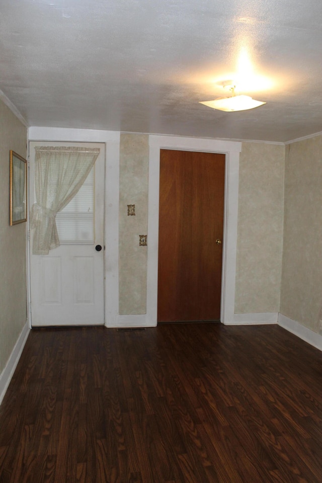 spare room featuring a textured ceiling and dark hardwood / wood-style floors