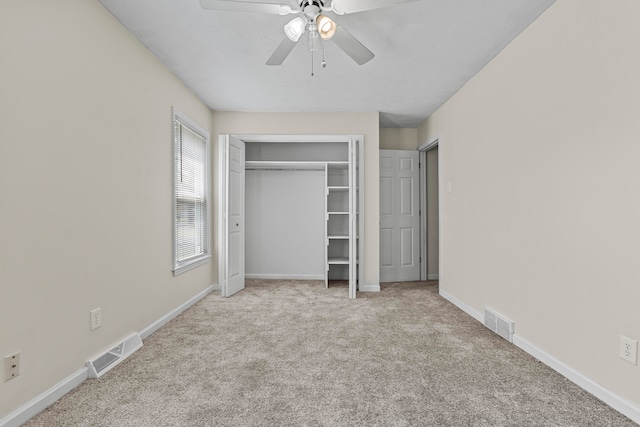 unfurnished bedroom featuring a closet, light colored carpet, and ceiling fan