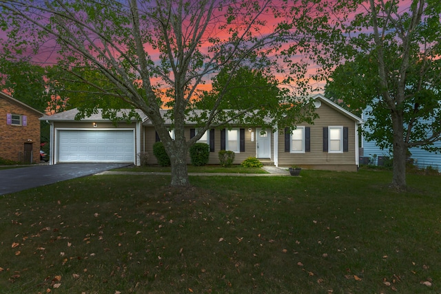 view of front of home with a garage and a lawn