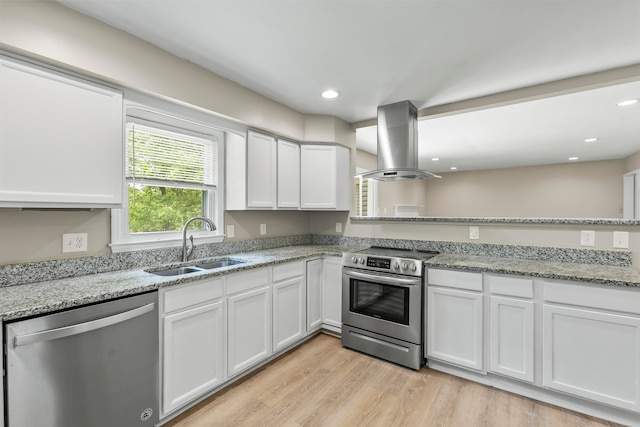 kitchen featuring sink, appliances with stainless steel finishes, light hardwood / wood-style floors, white cabinetry, and island exhaust hood