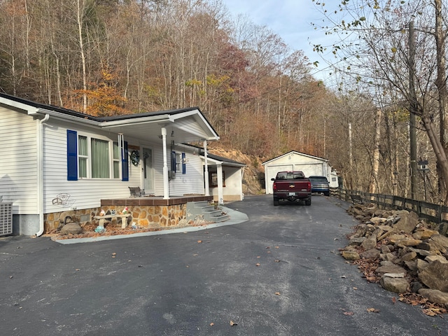 view of home's exterior featuring a garage, an outdoor structure, and covered porch