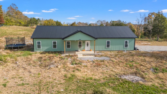 single story home featuring covered porch and a trampoline