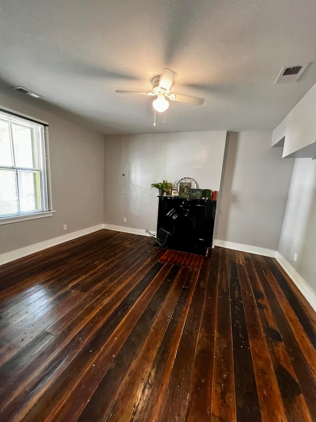 unfurnished room with dark wood-type flooring, ceiling fan, and a textured ceiling