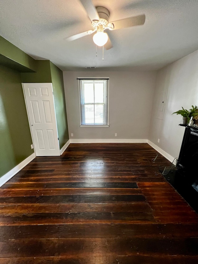 unfurnished bedroom featuring ceiling fan, dark hardwood / wood-style floors, and a textured ceiling